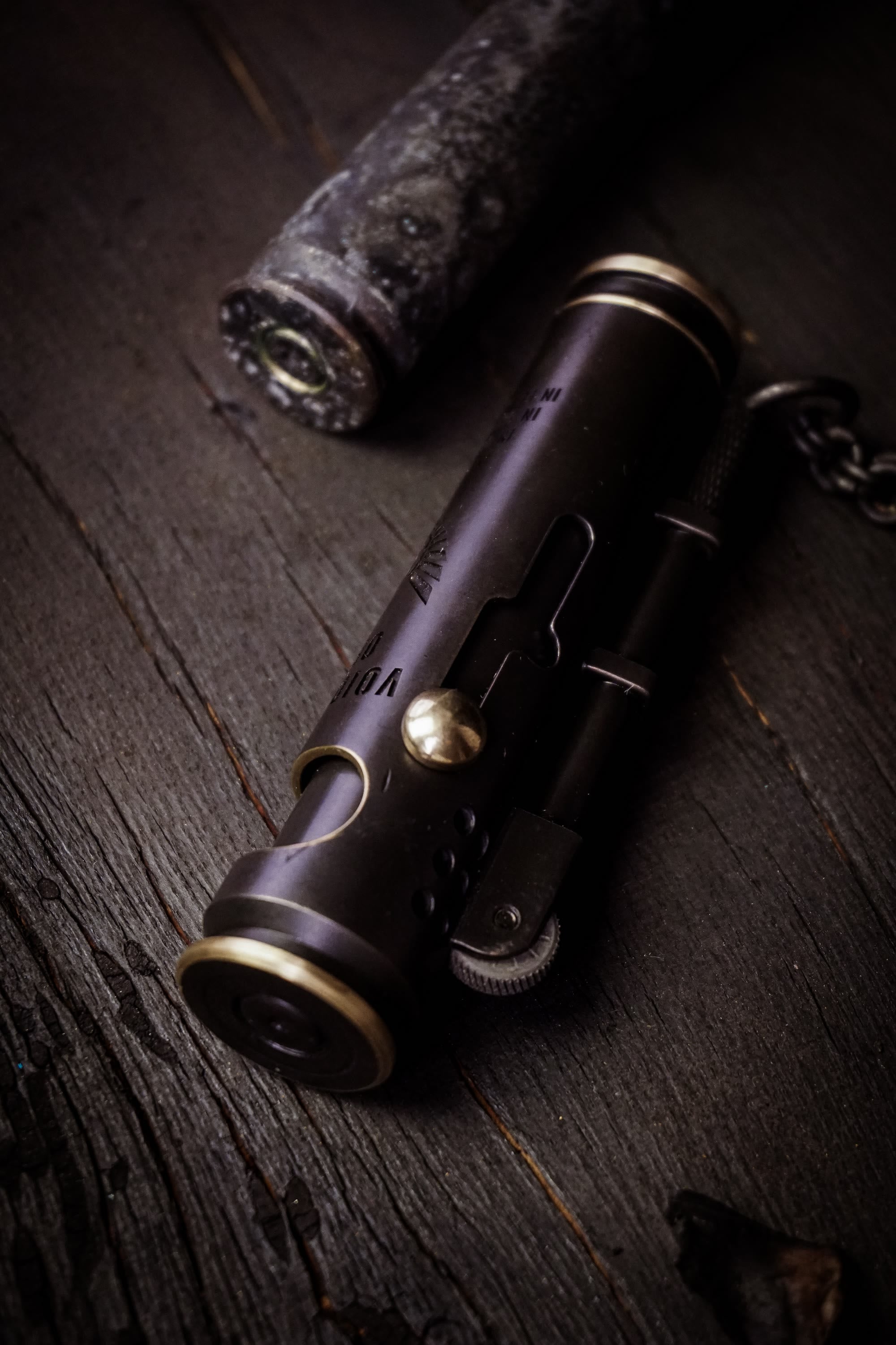 Large Void Korps side detail with brass fastener, lighter mechanism, and black finish