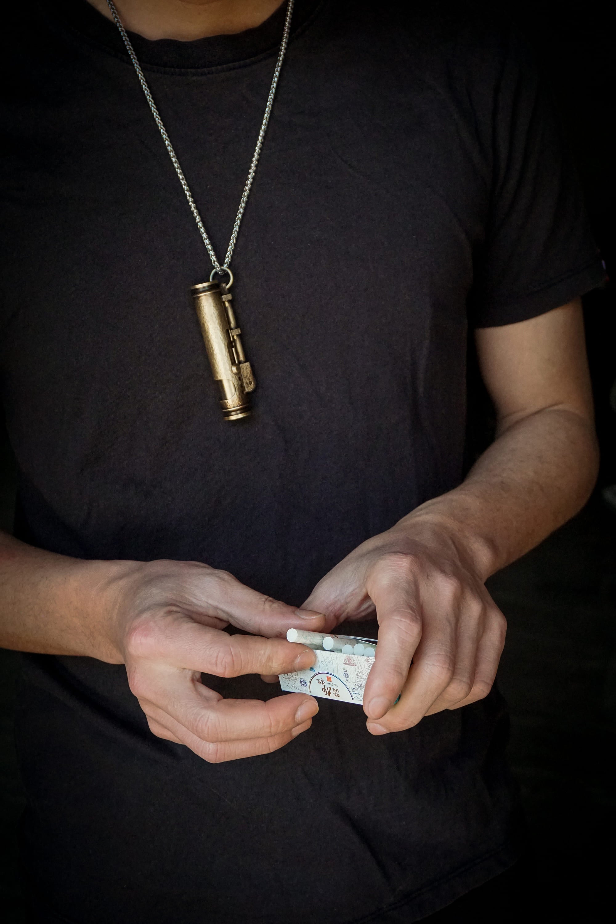 Cool Cigarette Lighter hanging around the neck, hand taking a cigarette from the cigarette box