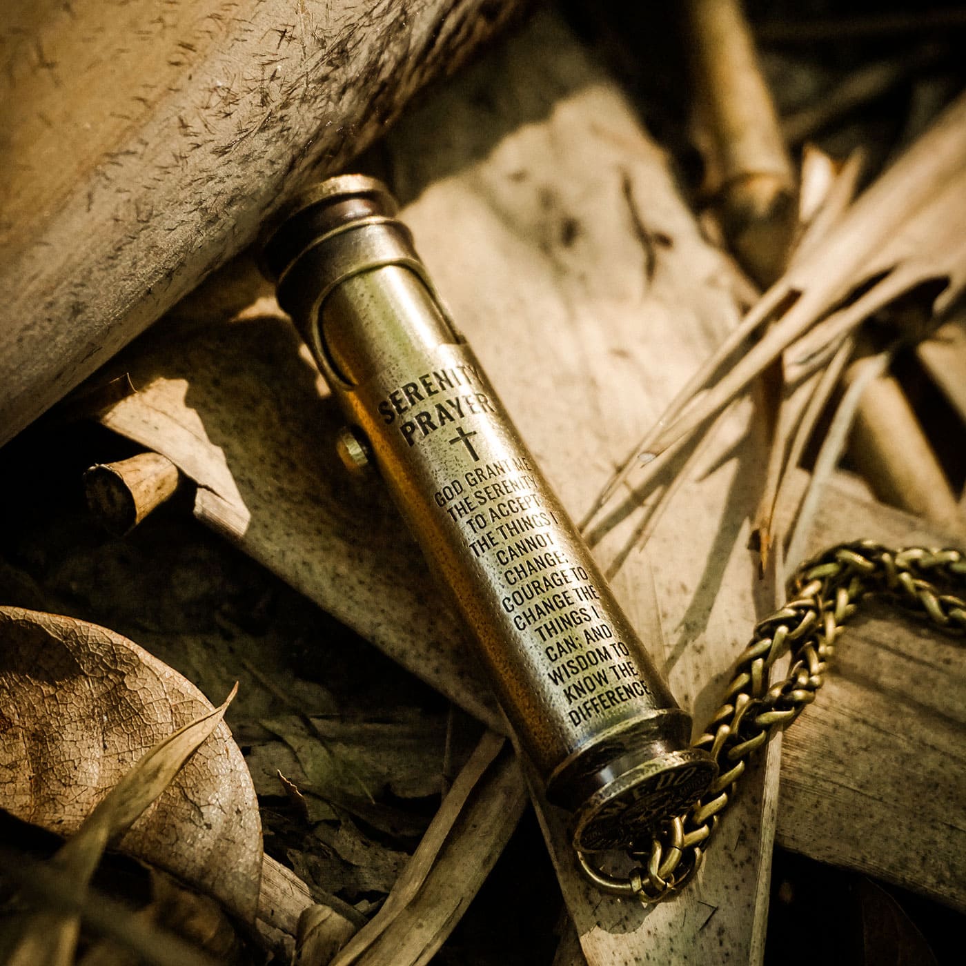 Faith-inspired engraved brass lighter displayed on natural wood