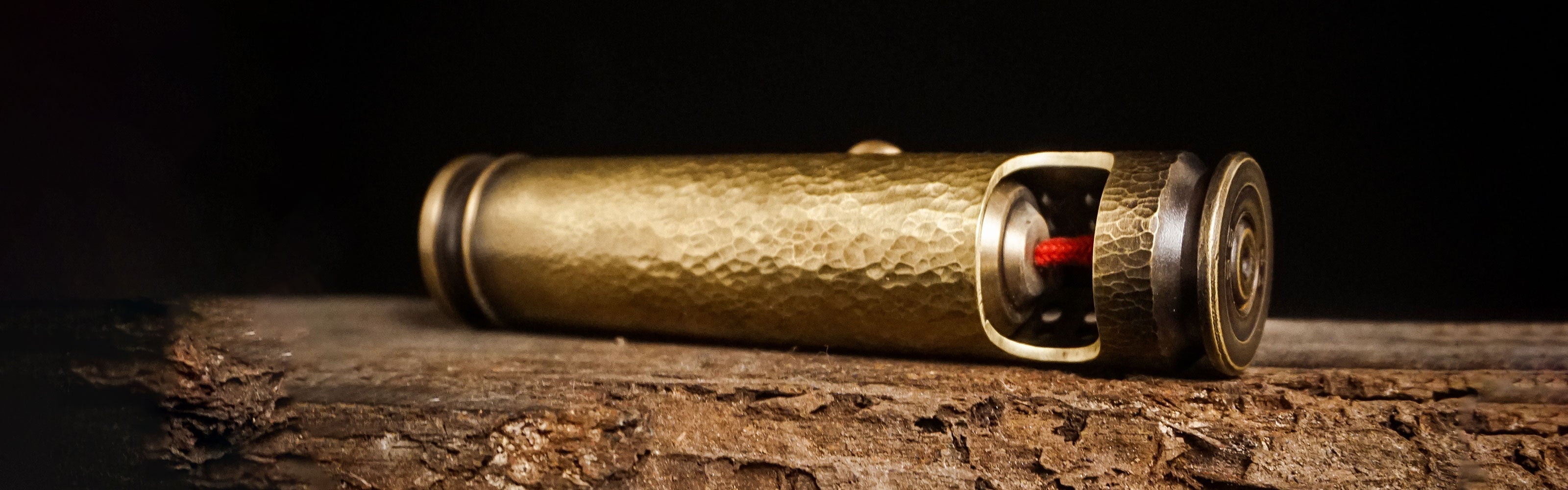 WEDO hammered brass lighter on dark workshop wood showing its hand-worked surface and real mechanism