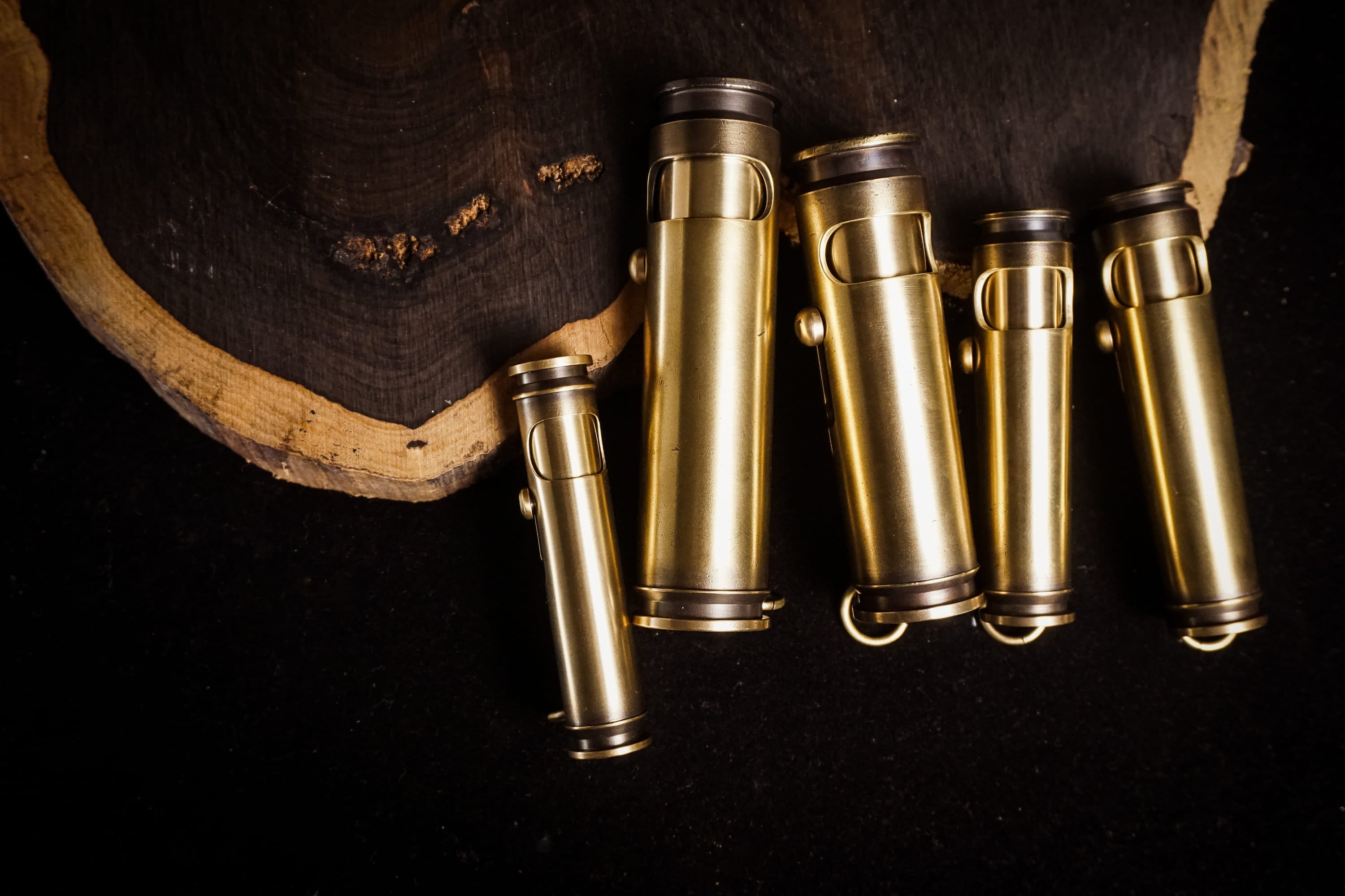 Real WEDO Classic brass lighters in different sizes on dark workshop wood