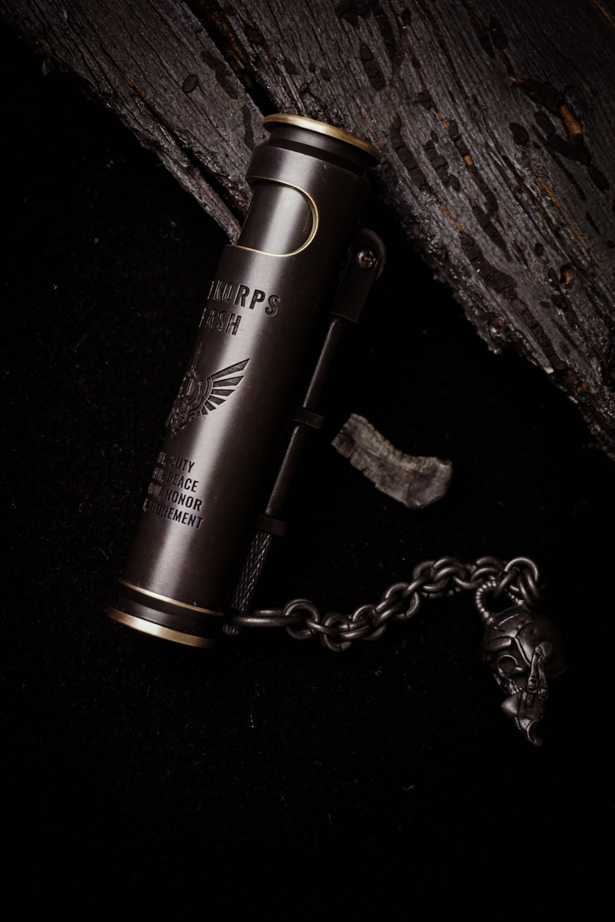 Large Void Korps skull lighter with Hero Pilot Skull Pirate Chain on weathered wood