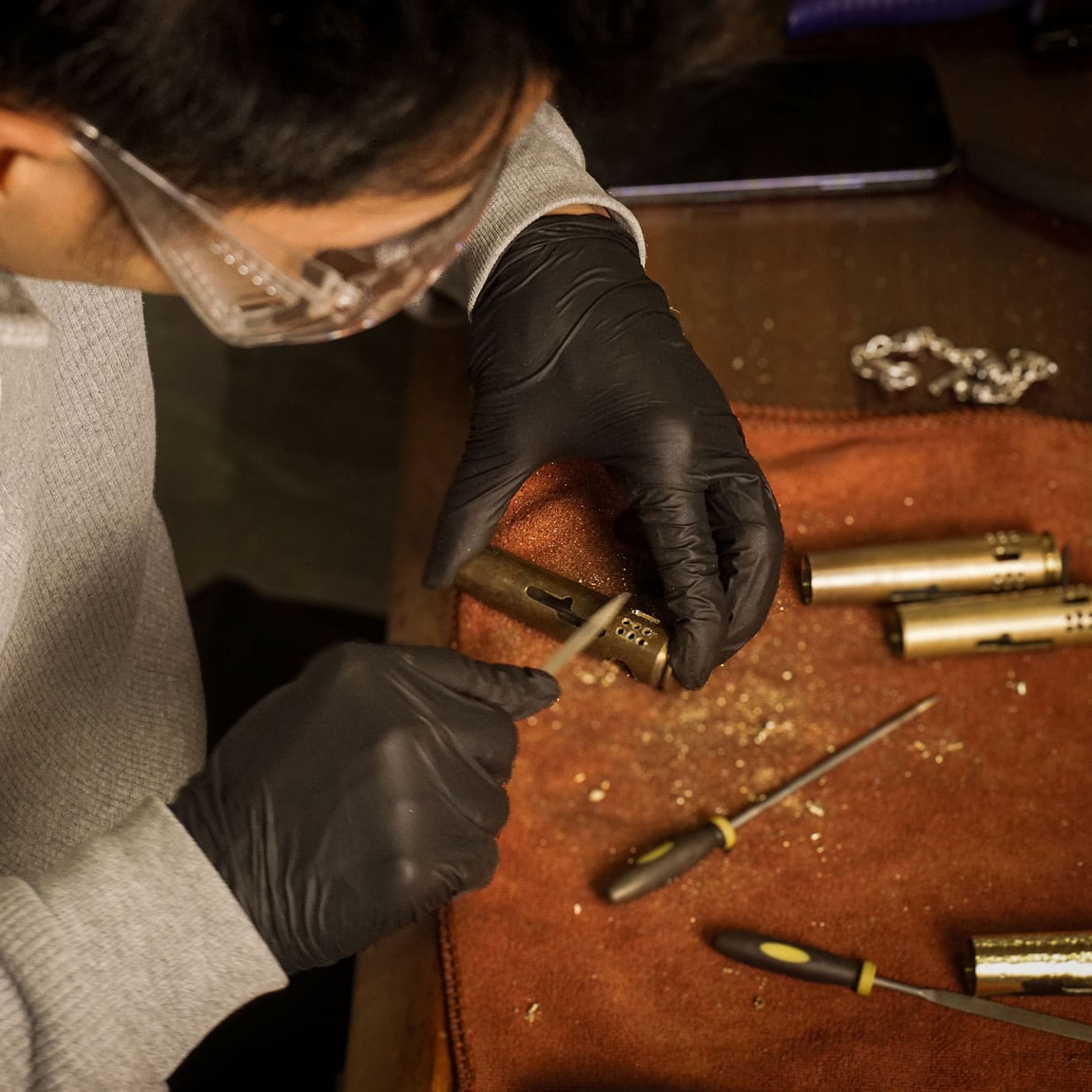 WEDO artisan handcrafting a brass shell lighter in the workshop